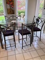 Full dining set view highlighting all four metal chairs