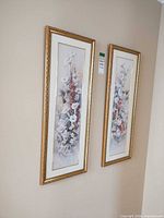 Both framed prints hanging on wall