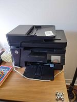 Front view showing HP LaserJet Pro MFP M127fw with touchscreen and output tray