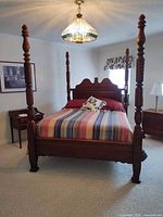 Full view of assembled queen four-poster bed showing headboard, footboard, posts