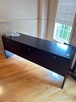 Front view of dark brown credenza showing three lockable fronts