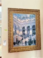 Full view of framed print on wall showing entire artwork and gilt frame