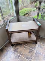 Full view of bar cart showing two cane shelves and casters