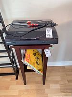 Overall view of Sony turntable on stand with RCA and power cables, records stored below