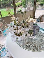 Vase with artificial flower arrangement on round table