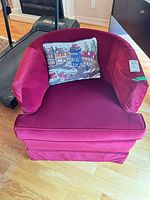 Front view of burgundy velvet tub armchair with decorative pillow