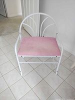 Front view of white metal chair with pink seat