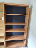 front view of light wood veneer bookcase with five shelves