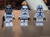 Front view of three minifigures standing side by side showing helmet and torso designs