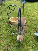 Full view of metal plant stand with three planters inserted