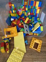 Bin with assorted LEGO Duplo bricks, plates, frames and wheels
