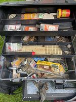 Open tackle box showing trays filled with lures, hooks, line, bait and accessories
