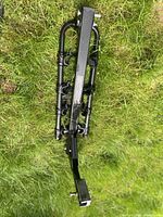 Full view of folded hitch bike rack on grass