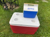 Large red Coleman cooler and small blue Igloo cooler closed