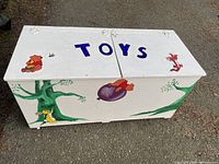 Front view of painted wooden toy chest showing graphics and TOYS lettering