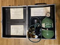 Open case showing oxygen cylinder, tubing, masks, instruction sheets
