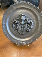 front view of pewter plate showing coat of arms