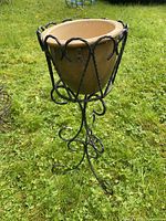 Wrought iron stand with tan ceramic planter
