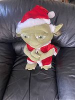Full view of Yoda plush seated on couch