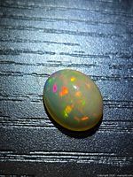 Top view of oval opal showing rainbow play-of-color