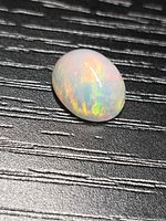 Top view of oval Ethiopian crystal opal showing play of colour