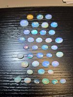Loose Ethiopian opal cabochons on black surface