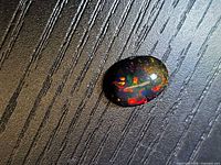 Top view of the black opal showing multicolour play-of-colour