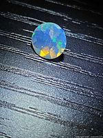Top view of round faceted Ethiopian opal showing play-of-colour