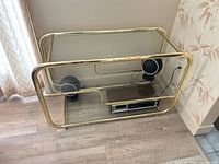 Front view of brass and glass TV stand