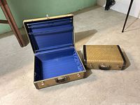 Open large suitcase showing blue interior; small suitcase closed alongside