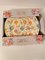 Box containing floral pumpkin plate with Coco + Lola branding visible