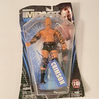 Front view of sealed Crimson Deluxe Impact Wrestling Series 10 figure with signature visible