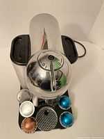 Top view of Nespresso Vertuo Evoluo machine with assorted pods on base