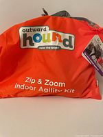 Front of orange Outward Hound carry bag showing branding and product name
