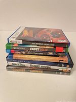 Stack of two video games and five movie cases