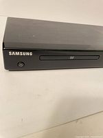 Front left view showing Samsung logo, power button, disc tray