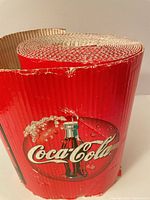 Rolled view showing Coca-Cola graphics and edge wear