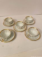 All five teacups with saucers arranged, showing overall set