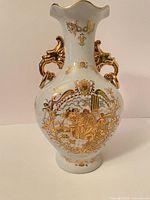 Front view of Limoges porcelain vase showing gold Fragonard scene and ornate handles