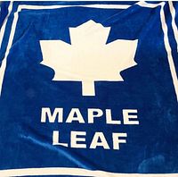 Full view of blue blanket with white maple leaf logo and text