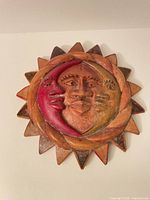 Front view of carved sun and moon plaque