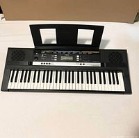 Front view of Yamaha PSR-E283 keyboard with music rest attached