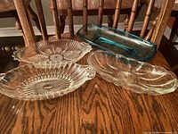 Four glass dishes laid on wooden chair seat