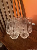 Group of eight crystal tumblers on chair showing overall quantity and style