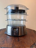 Front view of Breville digital steamer with three clear trays on stainless base