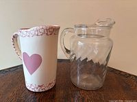 Front view of ceramic milk jug and clear glass juice jug