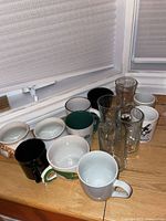 Group view of all glass and ceramic mugs on windowsill