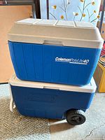 Stacked view showing both blue Coleman coolers, PolyLite 40 on top, wheeled cooler below