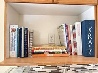 Shelf holding all cookbooks and Kraft binder