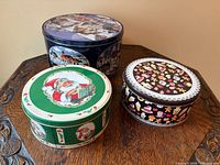 Three decorative round metal cookie tins